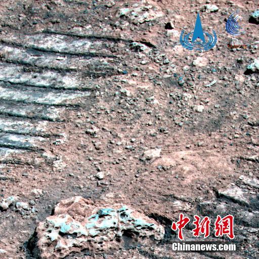 La foto composta da dati di più bande spettrali raccolti dalla fotocamera multispettrale mostra le rocce marziane sulla strada del rover. Si vedono le caratteristiche di tessitura della roccia e i solchi lasciati dal rover. (Foto dall'Amministrazione nazionale cinese per lo spazio)