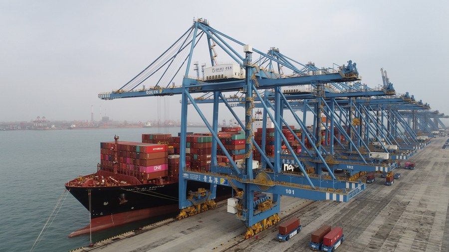 Container vengono caricati su una nave merci al molo automatico del porto di Qingdao, nella provincia dellla Cina orientale dello Shandong. (14 gennaio 2021 – Zhang Jingang/Xinhua)