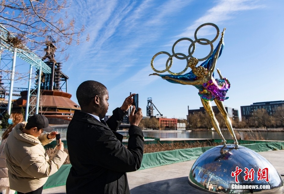 Edgar (secondo da sinistra), dall'Angola, che studia alla Capital Medical University, fotografa la scultura delle Olimpiadi invernali davanti all'ufficio del Comitato Organizzatore delle Olimpiadi Invernali di Beijing. (1 dicembre 2021 – China News Service/Hou Yu)