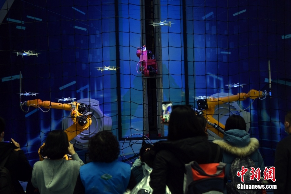 I visitatori guardano uno sciame di droni che si esibiscono in tandem con diversi bracci robotici al China Science and Technology Museum di Beijing,. (30 dicembre 2021 - China News Service/Sun Zifa)