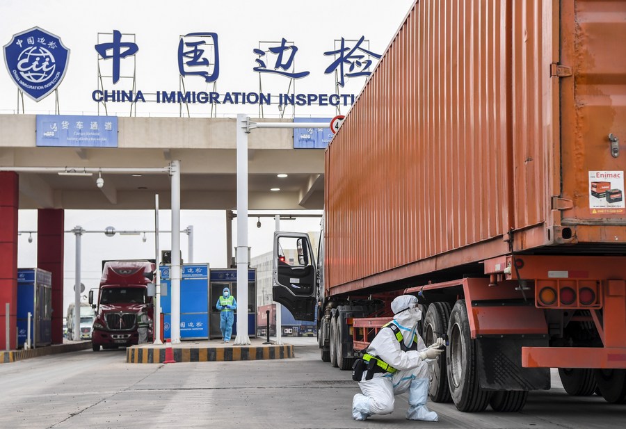 Un agente di polizia controlla un camion nel porto di Dongxing nella regione autonoma del Guangxi Zhuang, nella Cina del sud. (8 gennaio 2022 - Xinhua/Cao Yiming)