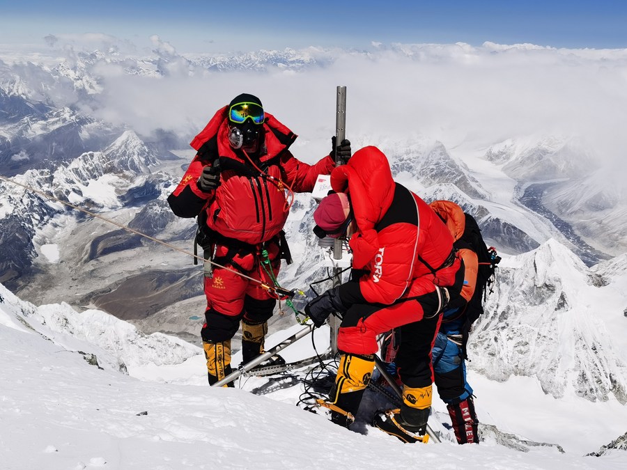 I membri di una spedizione cinese allestiscono una stazione di monitoraggio meteorologico automatico sul monte Qomolangma, anche noto con il nome "Everest". (4 maggio 2022 - Xinhua/Sonam Dorje)