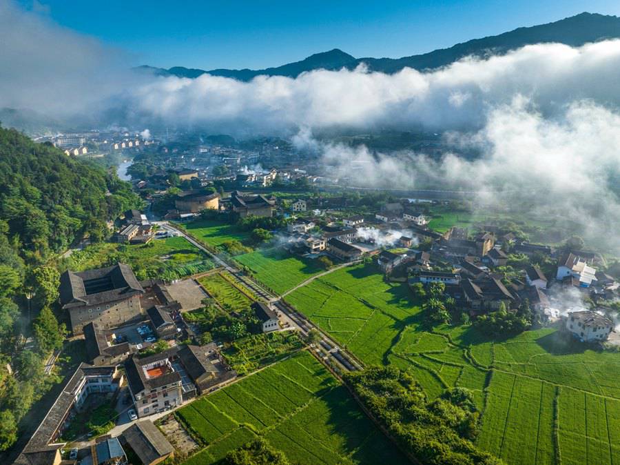 Vista mattutina dei Tulou del Fujian: un paese fatato avvolto da nuvole e nebbia