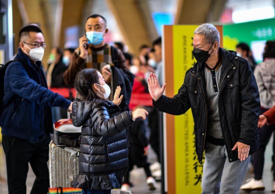 Una bambina dà il cinque al nonno venuto a prenderla all'aeroporto internazionale Changshui di Kunming. (15 gennaio 2023 - Xinhua/Jiang Wenyao)