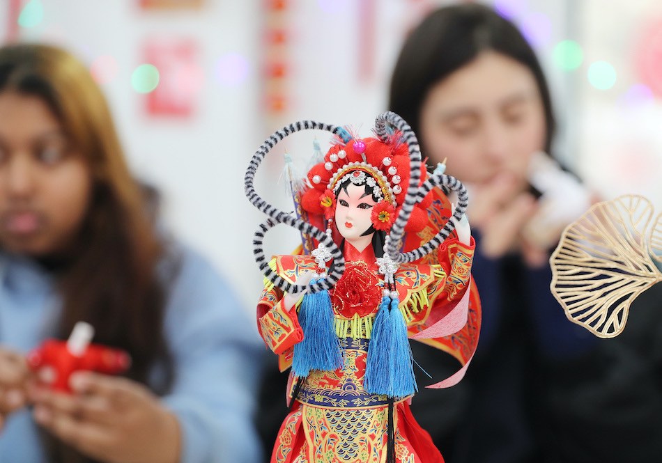 Qingdao, studenti stranieri fanno figurine di seta per festeggiare il capodanno cinese