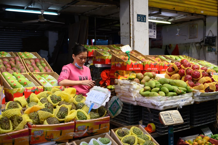 Una venditrice al suo banco in un mercato locale a Haikou, provincia di Hainan, Cina meridionale. (8 marzo 2022 - Xinhua/Hu Zhixuan)