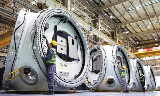 Addetti ai lavori assemblano i rotori delle turbine eoliche in una fabbrica nella zona di sviluppo economico e tecnologico di Lianyungang, provincia del Jiangsu, Cina orientale. (28 febbraio 2023 - Geng Yuhe/per China Daily)