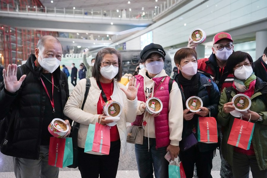 I turisti del primo gruppo turistico di Hong Kong posano per una foto di gruppo con souvenir in mano all'aeroporto internazionale Capital di Beijing. (6 febbraio 2023 - Xinhua/Ju Huanzong)