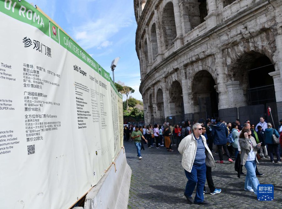 I visitatori passano davanti a un'insegna in cinese al Colosseo di Roma. (26 marzo 2023 – Jin Mamengni)