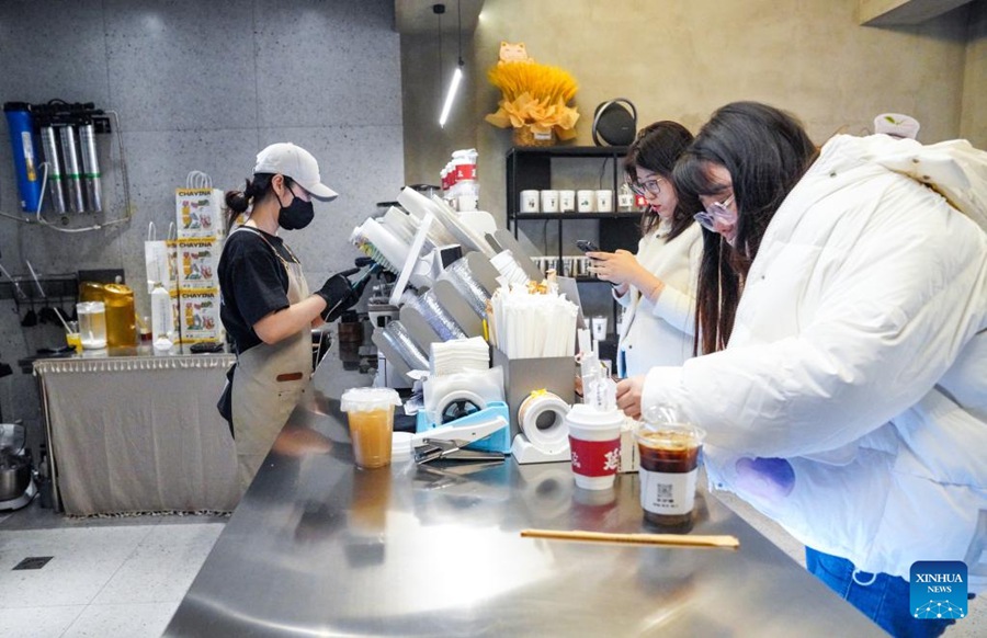 Li Xiangying prende gli ordini dei suoi clienti nella sua caffetteria. (4 aprile 2023 - Xinhua/Yan Linyun)