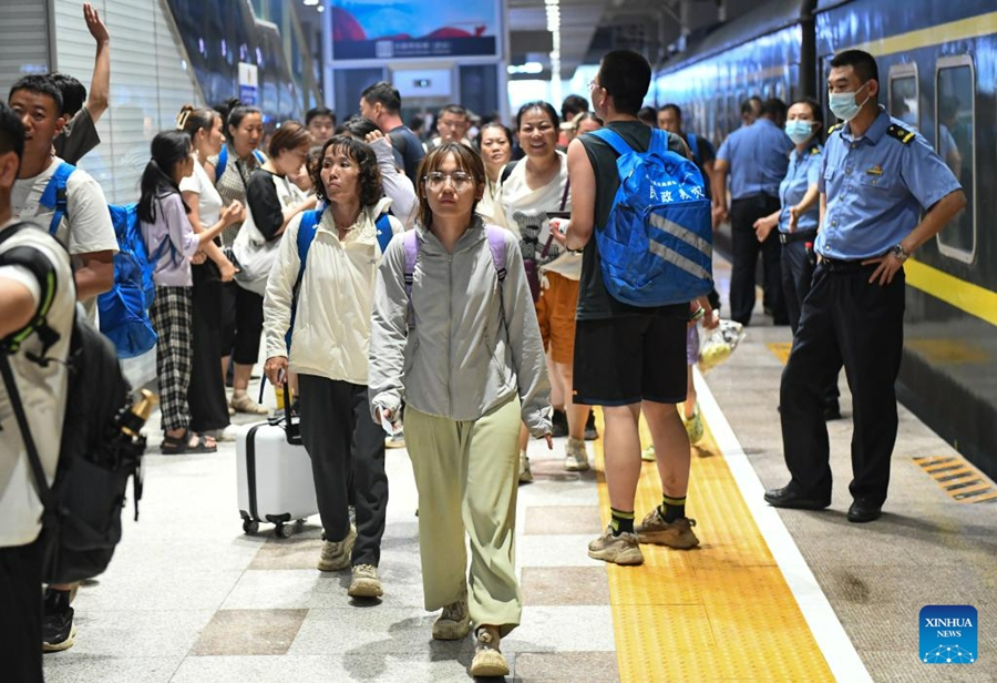 I passeggeri precedentemente rimasti intrappolati sul treno K396 nel distretto di Mentougou a causa delle forti piogge arrivano alla stazione di Beijing Fengtai. (2 agosto 2023 - Xinhua)