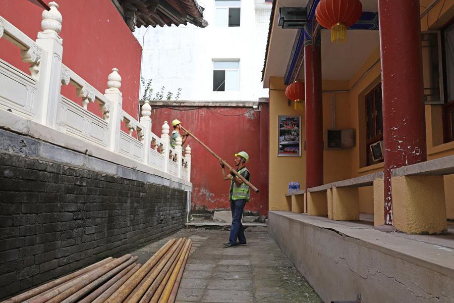 Operai rimuovono le impalcature dopo aver completato i lavori di riparazione nel tempio Yaowangmiao a Zhuozhou, nella provincia dello Hebei. (4 settembre 2023 - Xiong Huaming/China Daily)