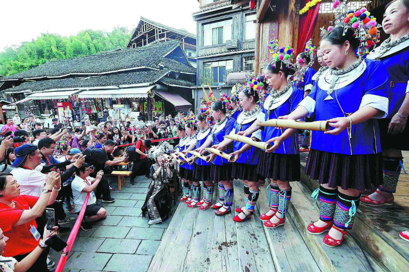 Persone del gruppo etnico Dong brindano ai turisti in un villaggio di Liuzhou, nella regione autonoma del Guangxi Zhuang. (16 settembre 2023 - Tan Kaixing/China Daily)