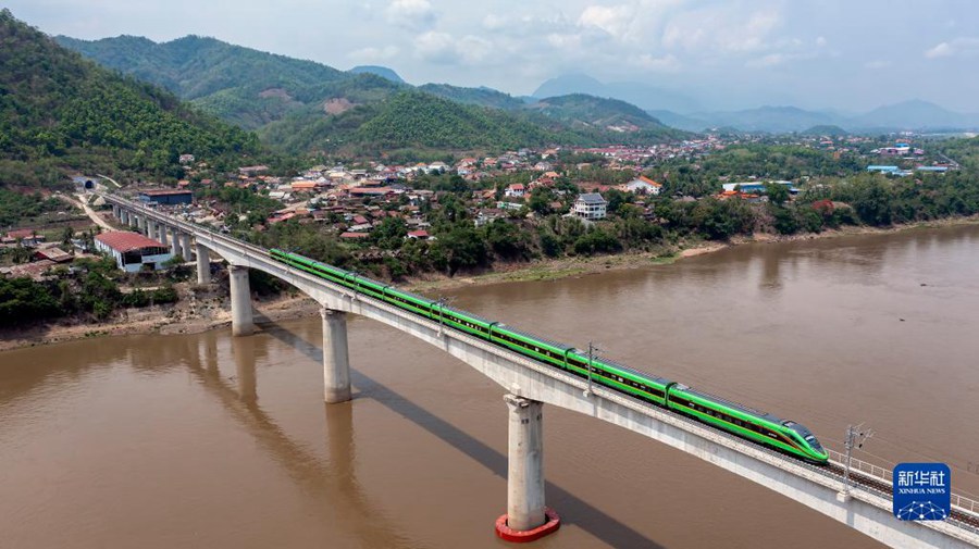 Il treno passeggeri della ferrovia Cina-Laos attraversa il ponte sul fiume Mekong a Luang Prabang, Laos. La ferrovia Cina-Laos, che si estende da Kunming (Cina) a Vientiane (Laos), per una lunghezza di 1035 chilometri, è un esempio vivido di collaborazione, costruzione congiunta e benefici comuni nell'ambito dell'iniziativa "Belt and Road".