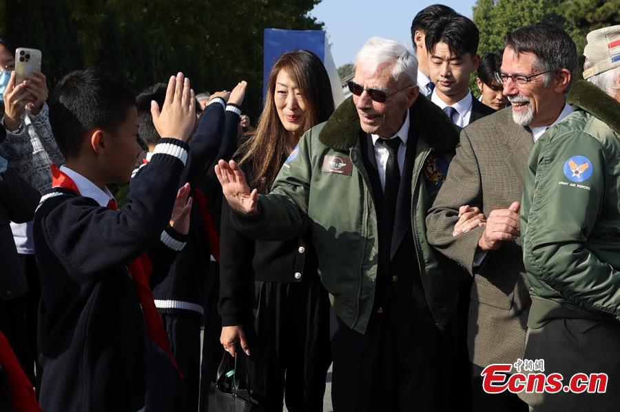 Harry Moyer, un pilota veterano americano di 103 anni delle Tigri Volanti della Seconda Guerra Mondiale, dà il cinque a uno studente cinese durante la sua visita al Museo della Guerra di Resistenza del Popolo Cinese contro l'Aggressione Giapponese a Beijing. (30 ottobre 2023 - China News Service/Jiang Qiming)