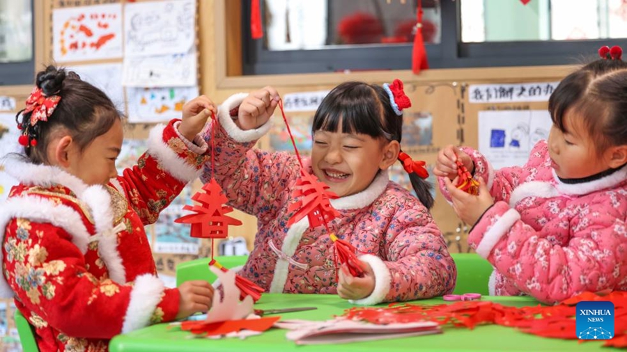 Bambini tagliano la carta in un asilo nella contea autonoma Dong di Yuping, nella città di Tongren, nella provincia del Guizhou. (16 gennaio 2024 - Hu Panxue/Xinhua)