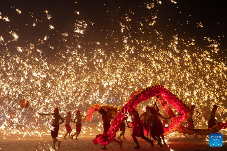 Attori si esibiscono in una danza del drago con fuochi d'artificio sotto una pioggia di ferro fuso al Volga Manor di Harbin, nella provincia nordorientale cinese dello Heilongjiang. (29 gennaio 2024 - Xinhua/Zhang Tao)