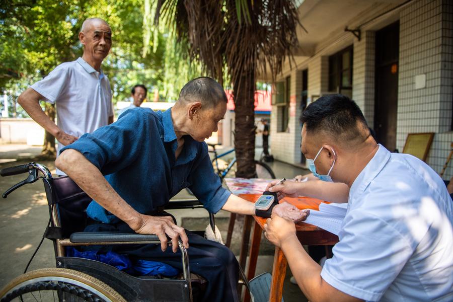 Un operatore sanitario conduce una visita medica per un residente anziano in una casa di cura nella contea di Anxiang, provincia dello Hunan. (21 giugno 2023 - Xinhua/Chen Sihan)