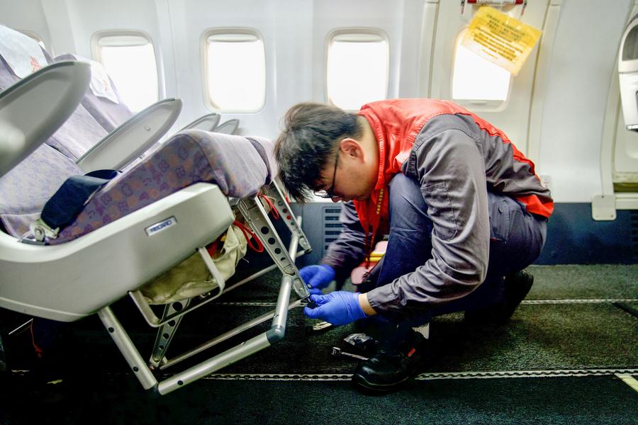 Un membro del personale della Grand China Aviation Maintenance Co. (GCAM) opera all'interno della cabina di un aereo in un hangar di una base di manutenzione aeronautica a Haikou, nella provincia di Hainan. (13 maggio 2024 - Xinhua/Zhang Liyun)