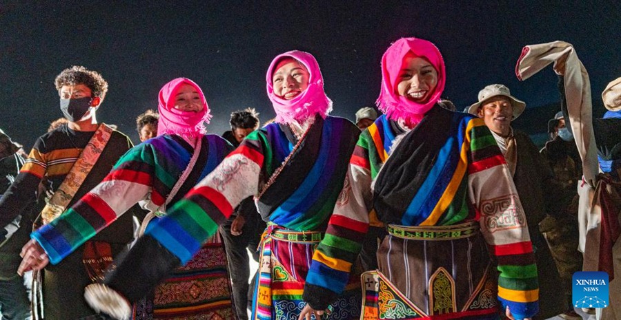 Abitanti locali ballano attorno a un falò durante una festa per celebrare lo scioglimento delle acque ghiacciate del Lago Namtso, nella regione autonoma dello Xizang, nel sud-ovest della Cina. (18 maggio 2024 – Xinhua/Tenzin Nyida)