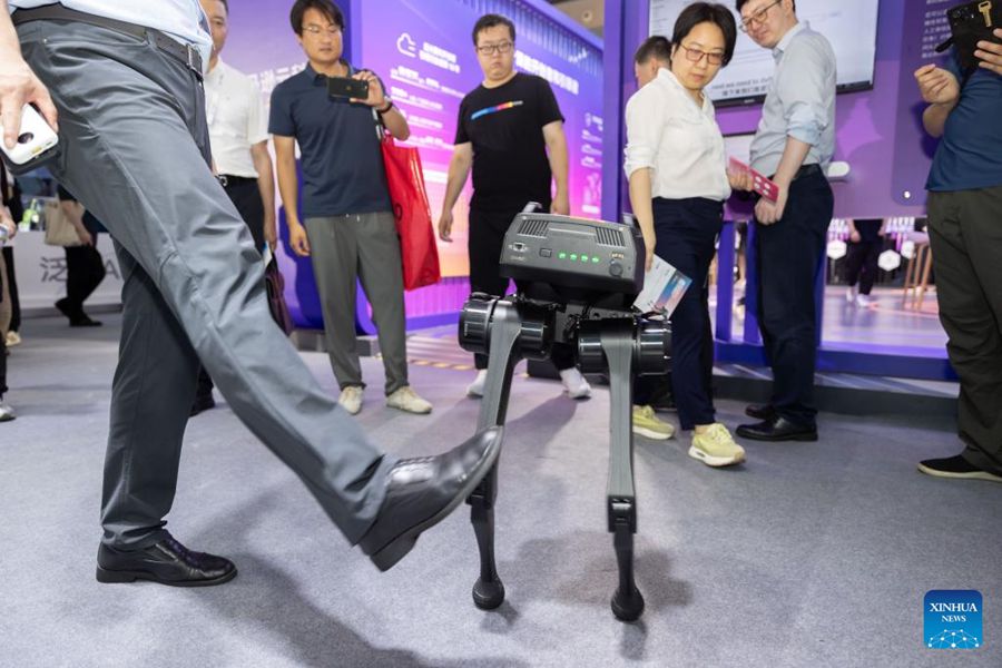 Un membro dello staff mostra un robot bipede che rimane in posizione verticale nonostante le interferenze durante la Conferenza Mondiale sull'IA del 2024 a Shanghai. (4 luglio 2024 - Xinhua/Wang Xiang)