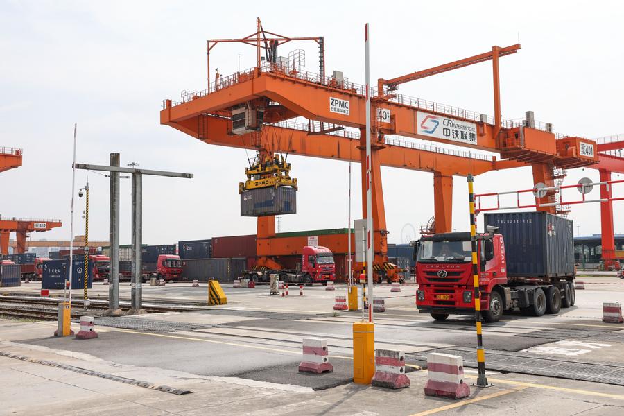 Un veicolo trasferisce un container nel porto del nuovo corridoio commerciale internazionale terra-mare nel Chongqing International Logistics Hub Park, nella Cina sud-occidentale. (30 luglio 2024 - Xinhua/Lyu Shuai)