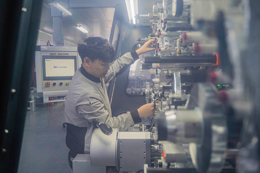 Un membro dello staff aziona una macchina per l'avvolgimento di condensatori a pellicola presso Savy Machine, situata nel distretto Xinbei di Changzhou, nella provincia orientale cinese del Jiangsu. (Quotidiano del Popolo Online/Gao Chao)