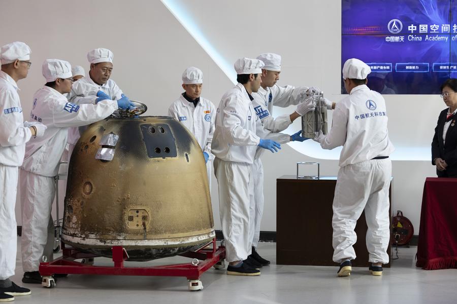 Ricercatori pesano i campioni lunari del Chang'e-6 durante la cerimonia di apertura del returner presso la China Academy of Space Technology della China Aerospace Science and Technology Corporation a Beijing, capitale della Cina. (26 giugno 2024 - Xinhua/Jin Liwang)