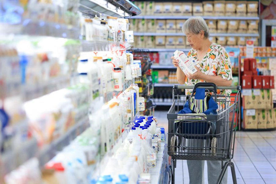 Una cliente sceglie il latte in un supermercato di Nanjing, capoluogo della provincia orientale cinese del Jiangsu. (12 giugno 2024 - Xinhua/Su Yang)