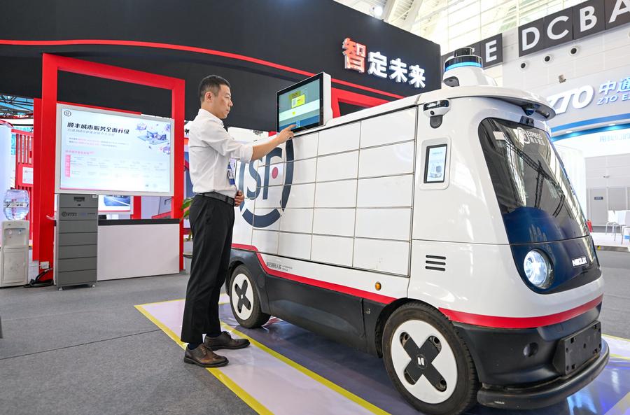 Un espositore programma un veicolo di consegna autonomo senza conducente per servizi di corriere esposto alla World Intelligence Expo 2024 a Tianjin, nella Cina settentrionale. (20 giugno 2024 - Xinhua/Sun Fanyue)